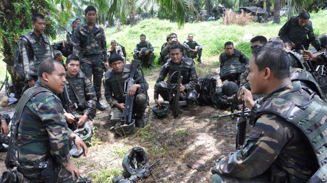 Malaysian soldiers confer during an operation in Sungai Nyamuk, a village adjacent to Kampung Tanduo, Malaysia, March 14, 2013. A contingent of Malasian troops is now heading ro Somalia.